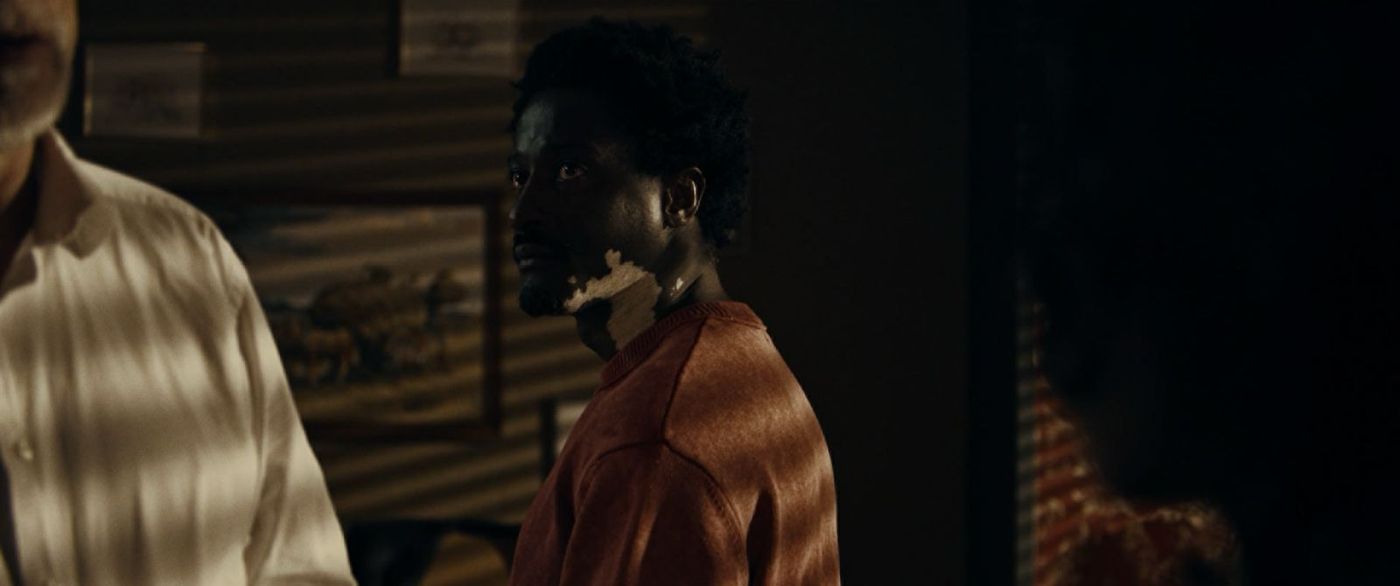 Mamadou stands inside a stark institutional corridor